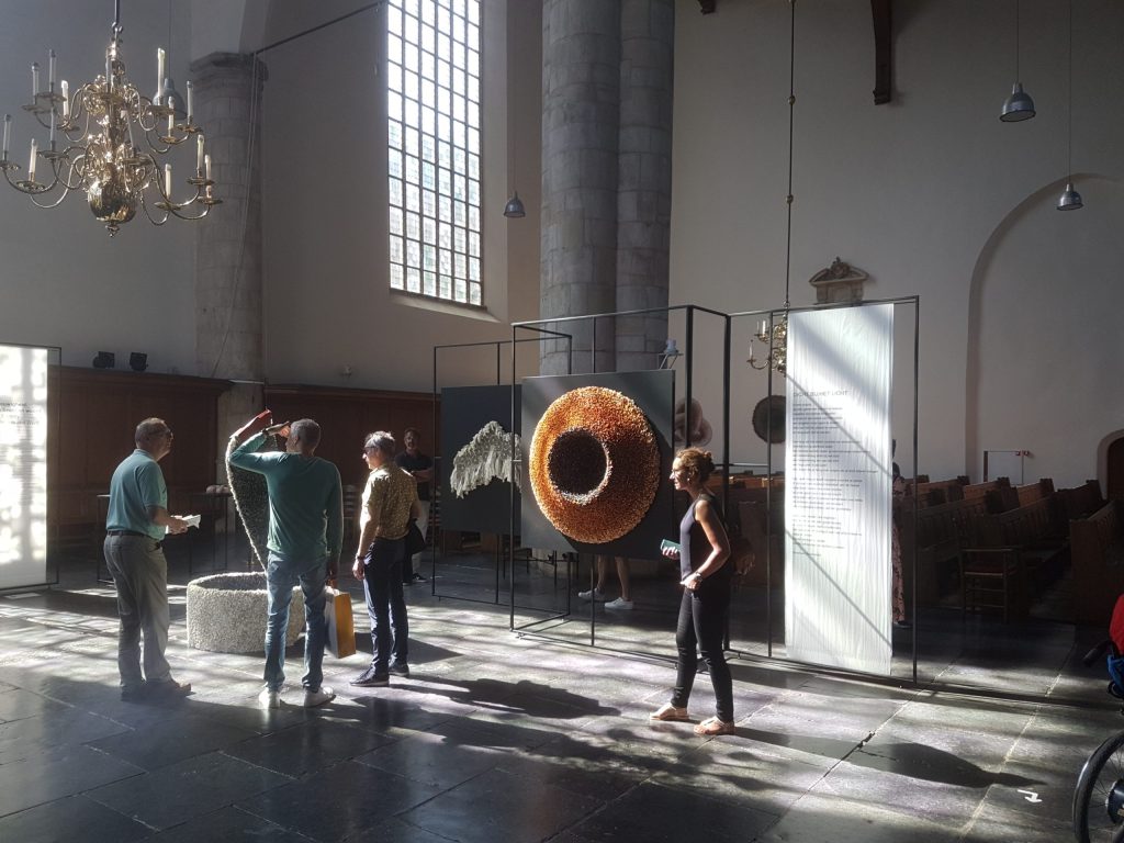 Foto uit jaarverslag 2022 van het schip van de Kloosterkerk Den Haag met papierkunstobjecten uit de tentoonstelling Tijd en Eeuwigheid.